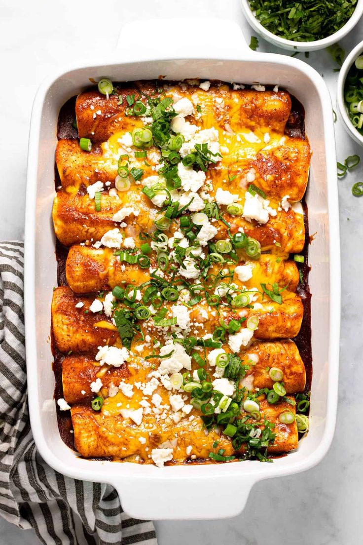 a casserole dish filled with mexican food and garnished with green onions