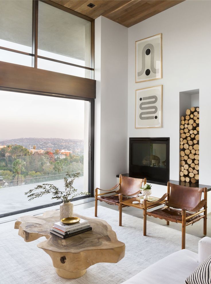 a living room with two chairs and a coffee table in front of a large window