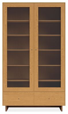 a wooden bookcase with glass doors on the front and bottom shelves, against a white background