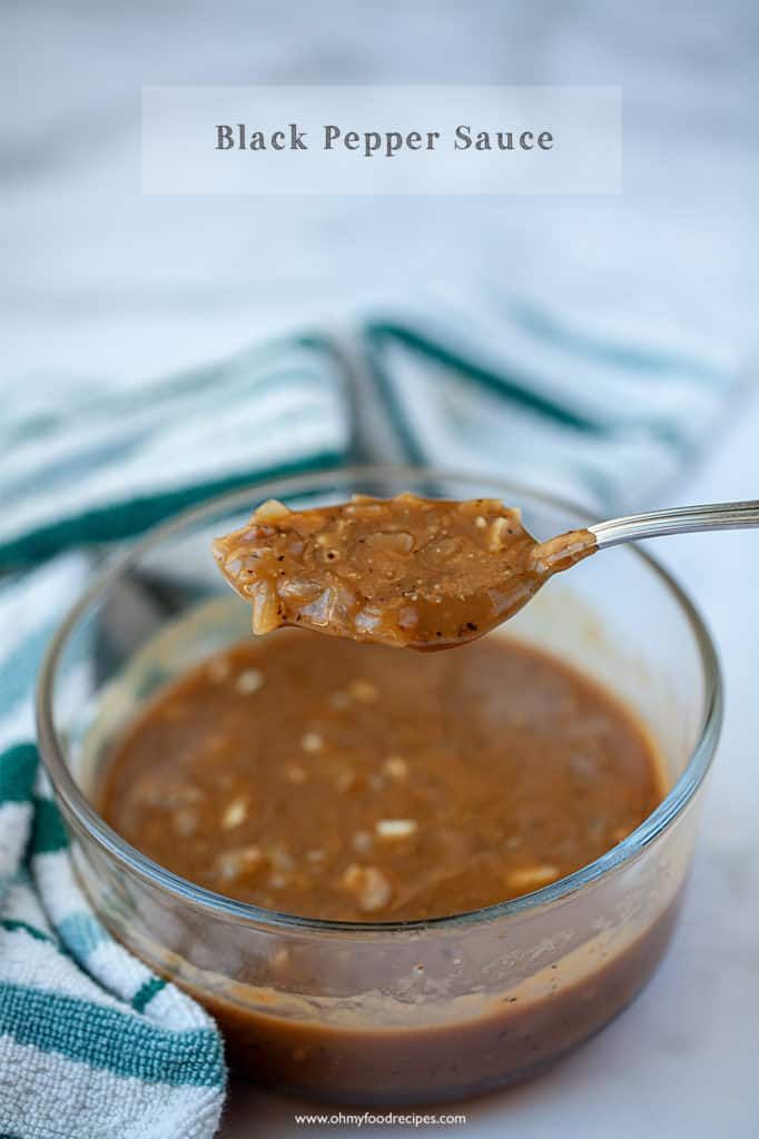 a spoon full of peanut butter on top of a glass bowl with a blue and white towel