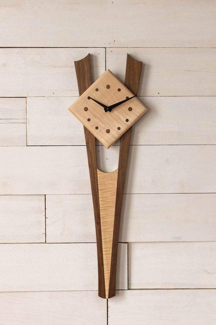 a wooden clock is hanging on the wall