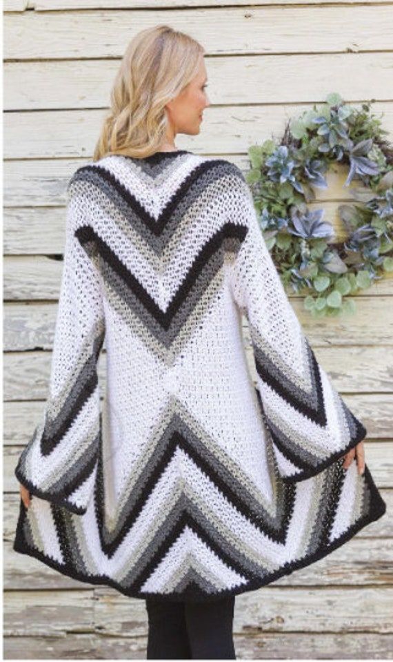 a woman wearing a white and black crocheted sweater