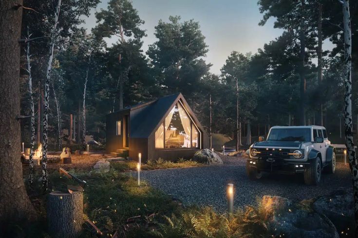 a truck parked next to a cabin in the woods