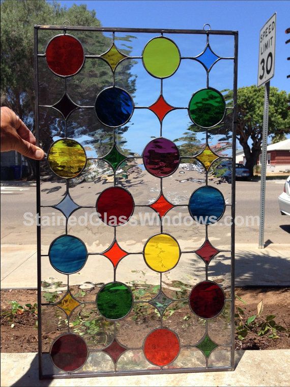 a colorful stained glass window sitting on top of a sidewalk next to a street sign