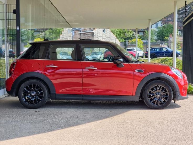 a red mini cooper parked in front of a building