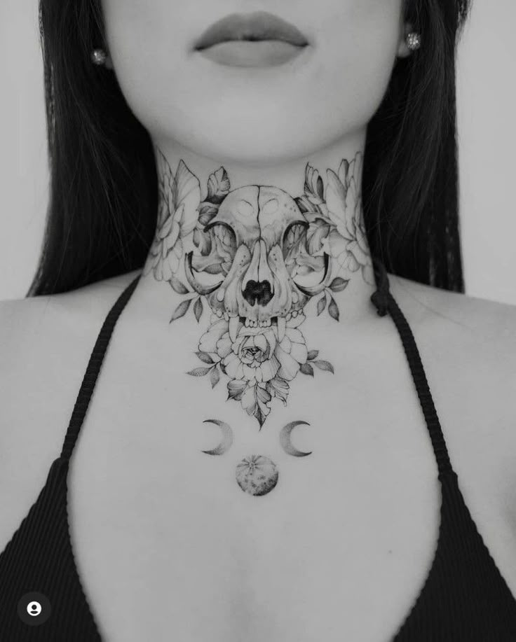 a woman wearing a black bra with flowers and skulls on her chest is looking at the camera