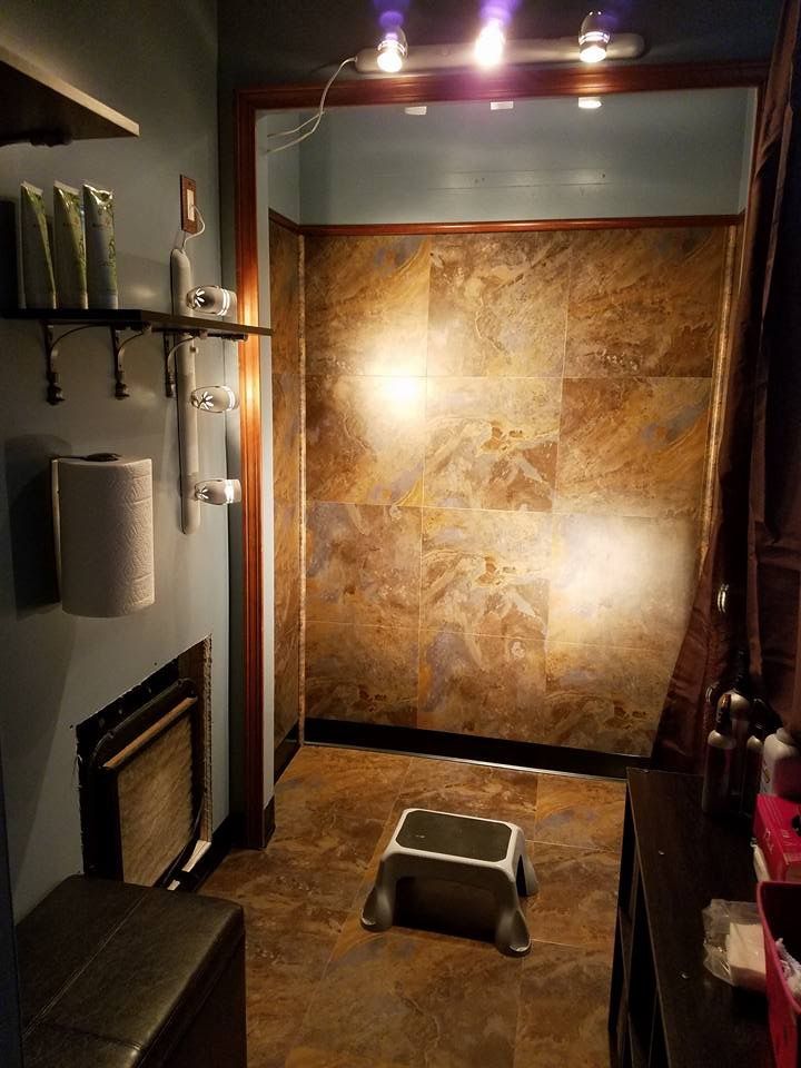 a bathroom with a toilet and a shower stall in the corner, next to a wall mounted heater