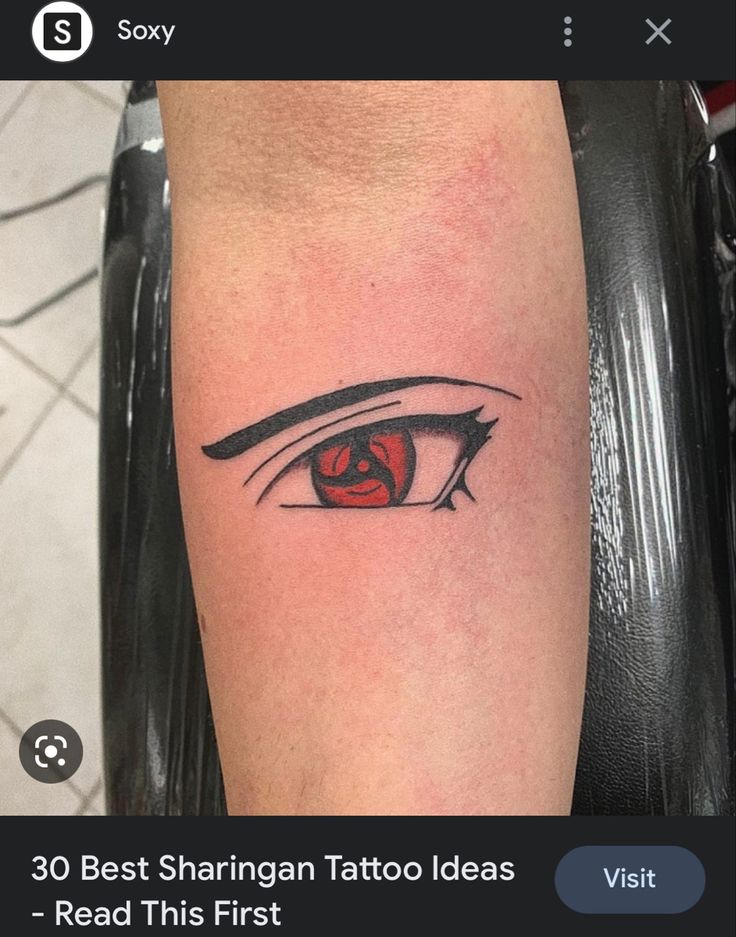 an eye tattoo on the leg of a person with red eyes and black lines around it