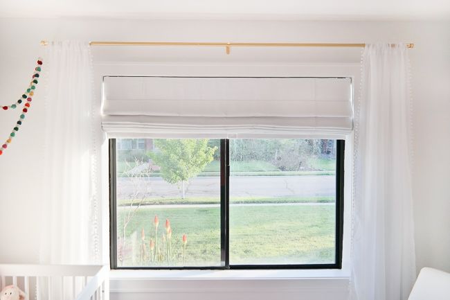 a baby's room with a crib and window