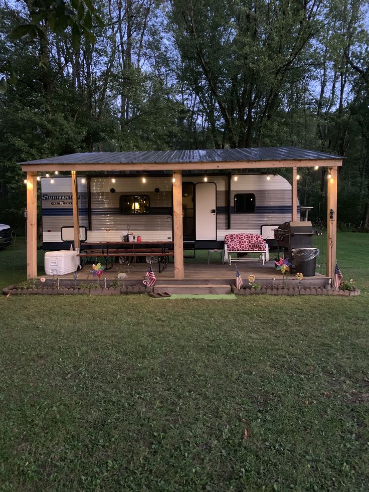 a mobile home sits in the middle of a grassy area with lights on it's roof