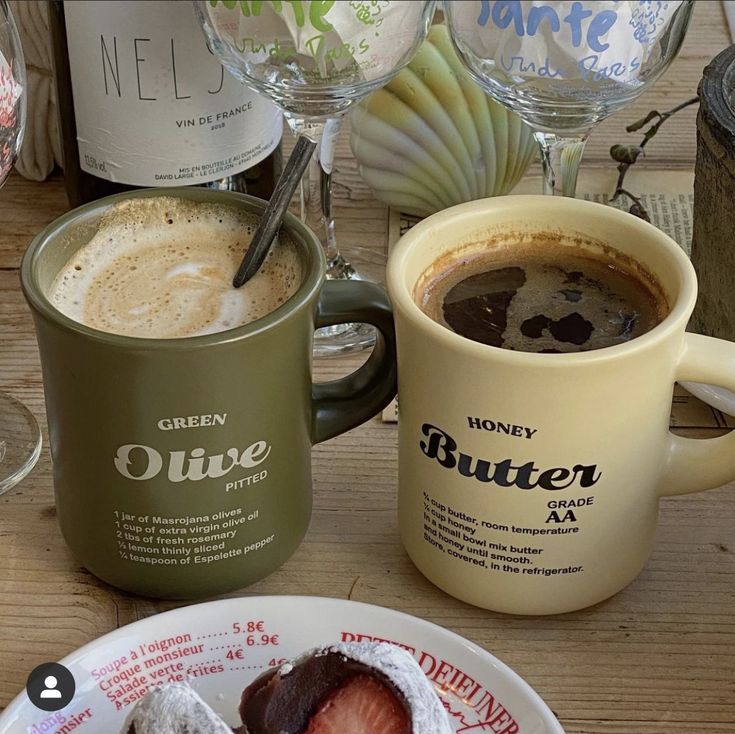 there is a cup of coffee and some pastries on the table next to each other