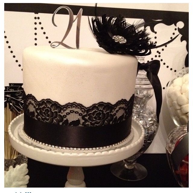 a white and black cake with lace on top