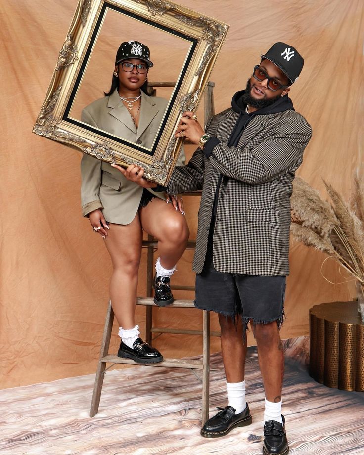 a man and woman holding up a framed photo