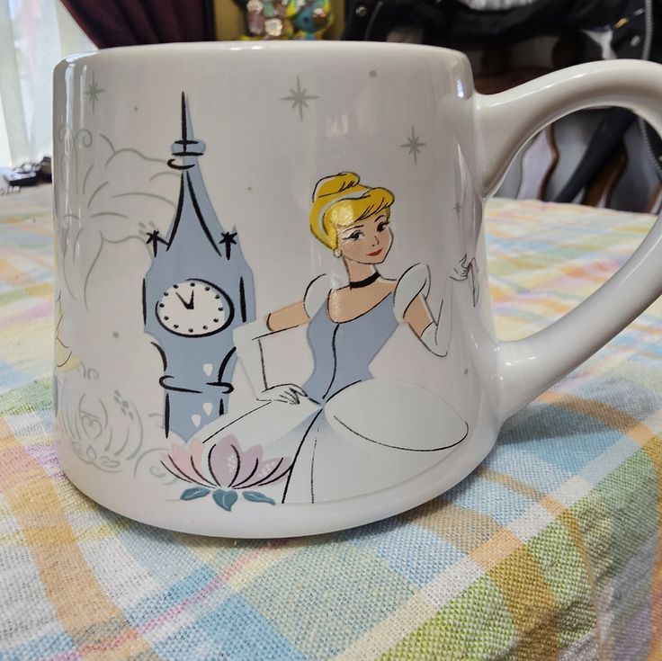 there is a coffee mug with a princess on it and a clock in the background