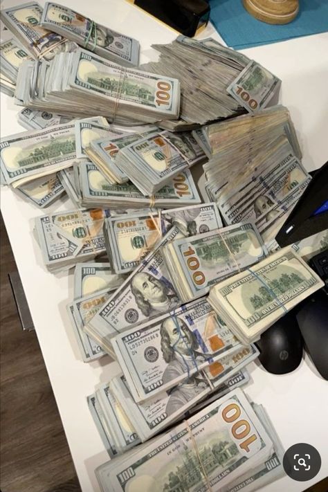 a pile of money sitting on top of a computer mouse