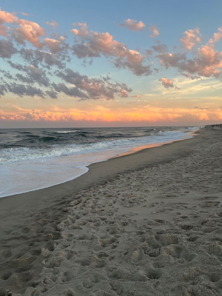 the sun is setting over the ocean and beach