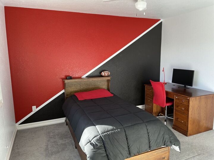 a bed room with a neatly made bed and a flat screen tv on the wall