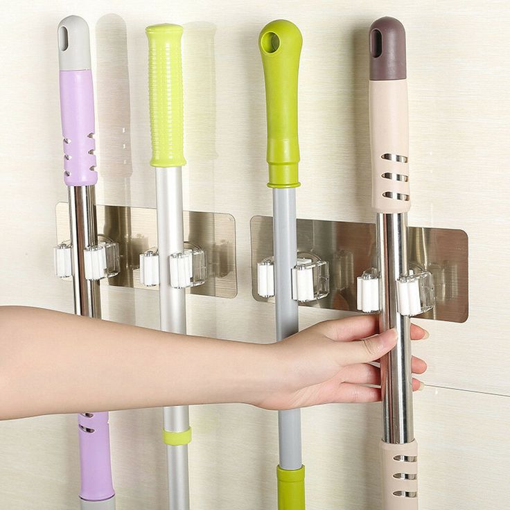 a person is holding onto a wall mounted rack with several different colored items on it