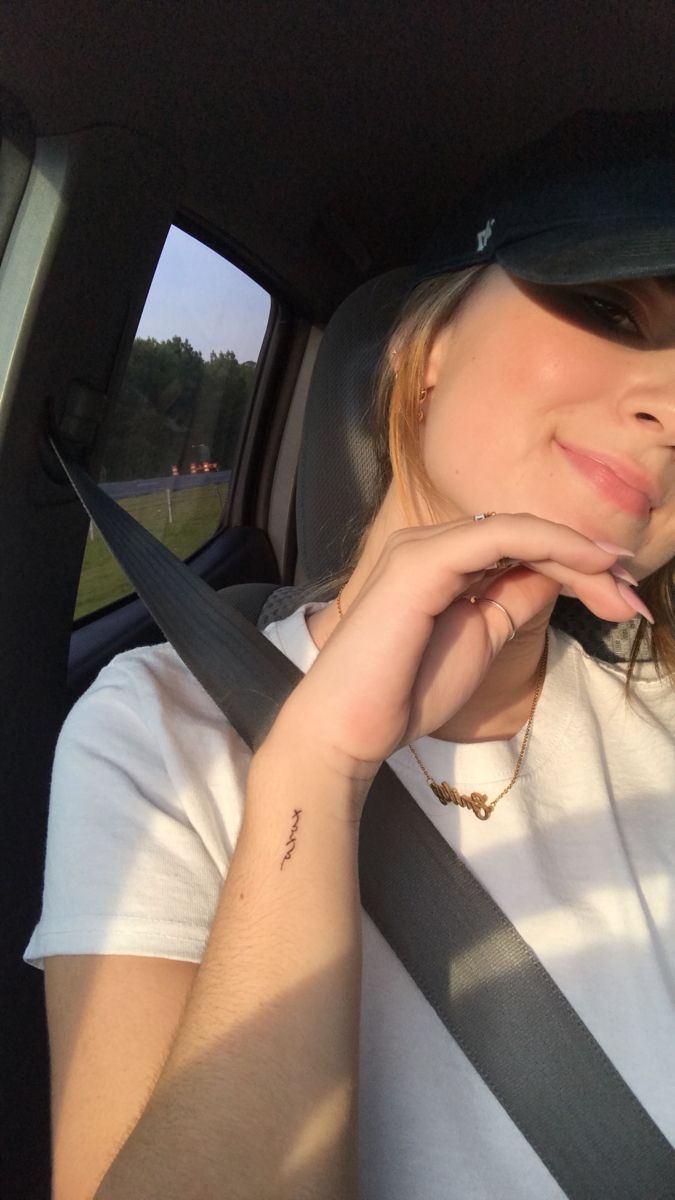 a woman sitting in the back seat of a car with her hand on her chin