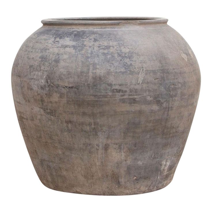 a large gray vase sitting on top of a white surface