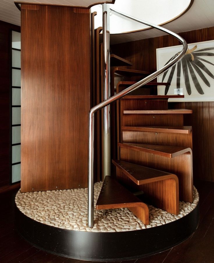 a spiral staircase with wood paneling and metal handrail