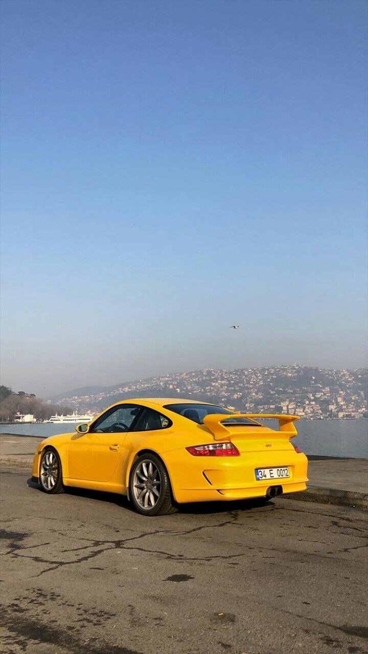 a yellow sports car parked on the beach