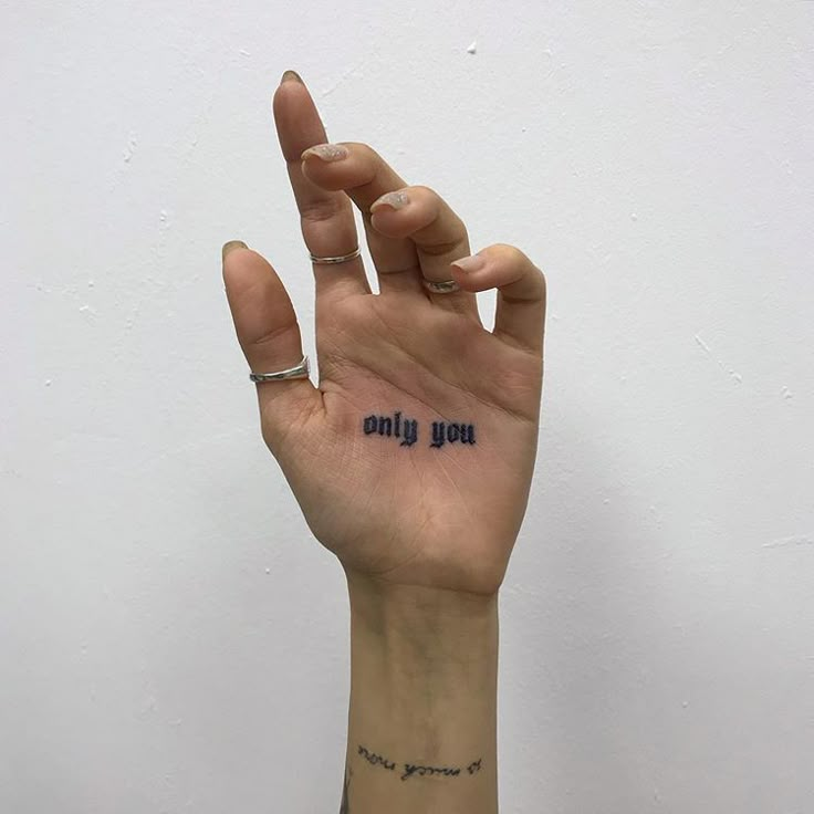 a woman's hand with the word only you tattooed on her left index finger