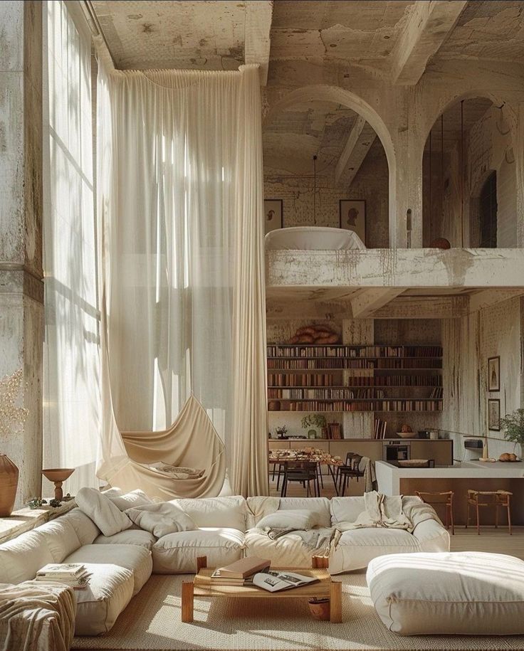 a living room filled with lots of white furniture and curtains on the windowsills