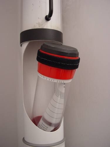 a red and black cup holder attached to a white wall