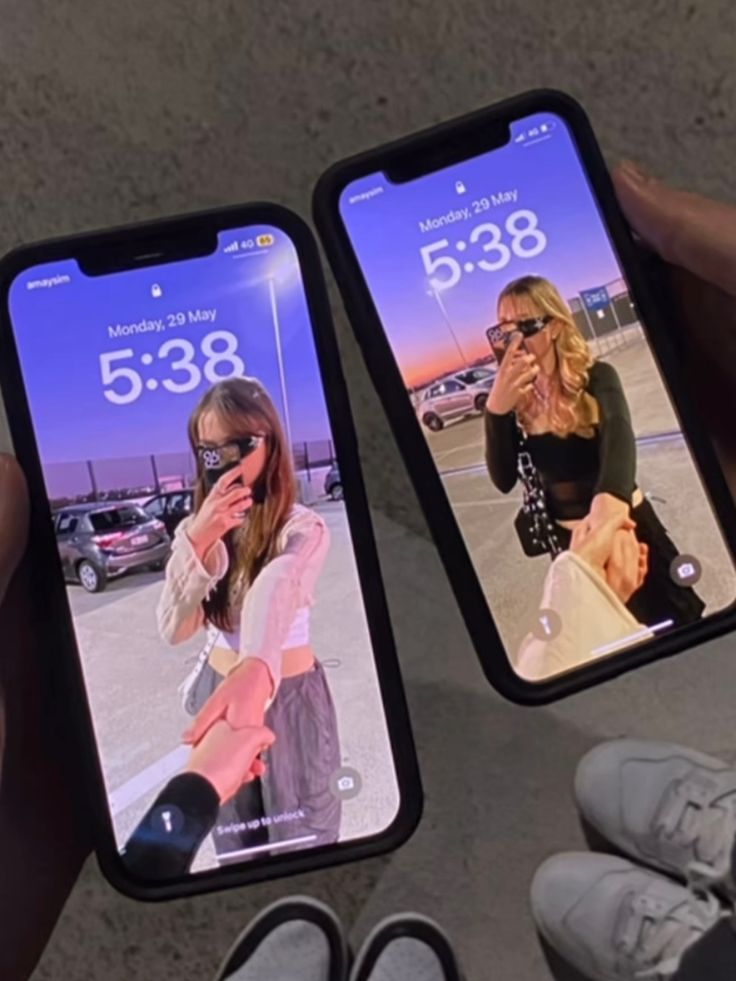 two people holding up their cell phones with pictures on them