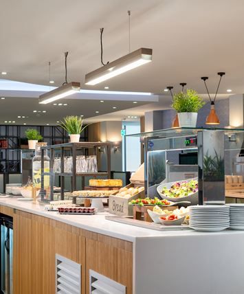 a buffet area with many plates and bowls on the counter, along with other food items