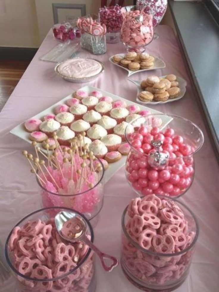 the table is covered with pink and white desserts