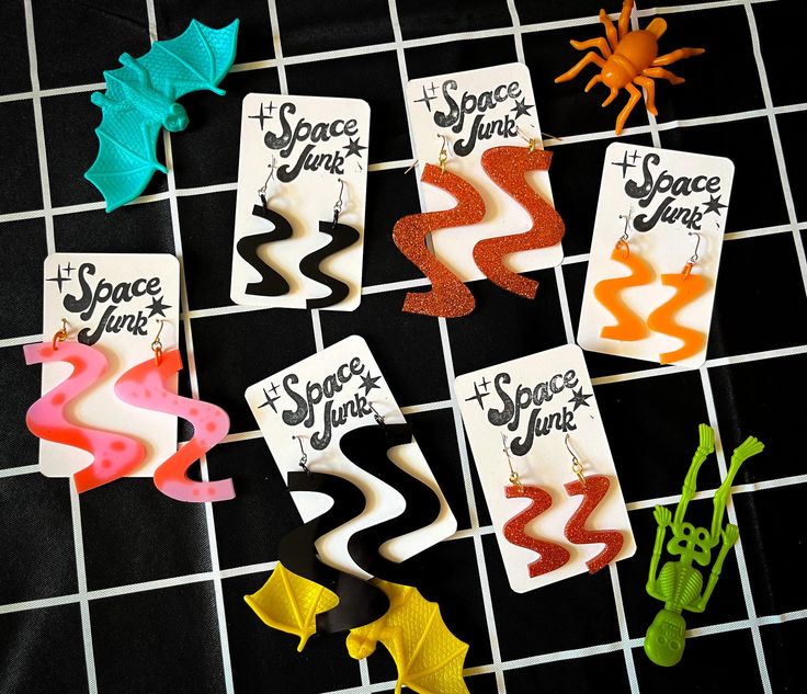 several different types of earrings sitting on top of a tiled floor next to each other