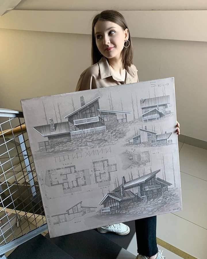 a woman holding up a drawing in front of her face