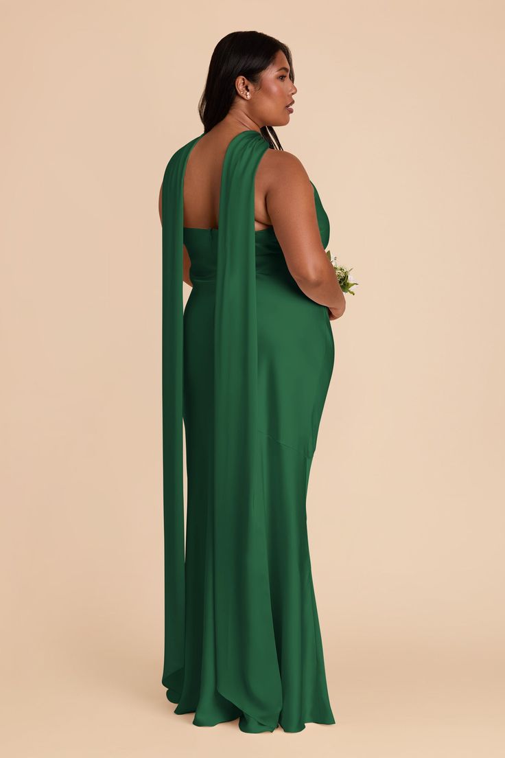 a woman in a green dress with her back to the camera