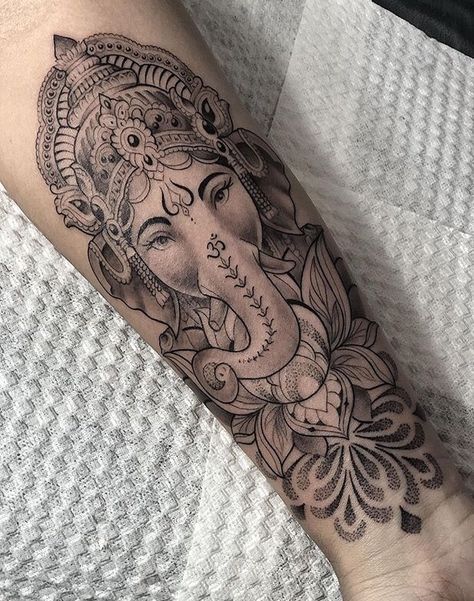 an elephant head tattoo on the right arm and leg, with flowers around its neck