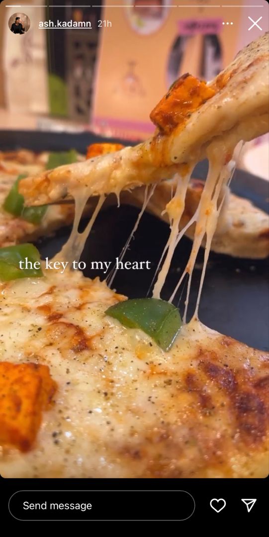 someone is taking a slice of pizza with the words, the key to my heart