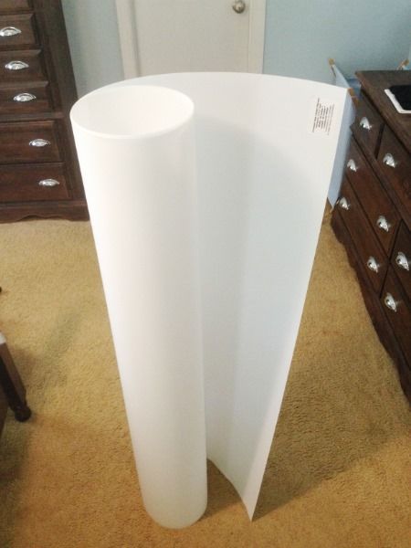 a tall white vase sitting on top of a carpeted floor next to a dresser