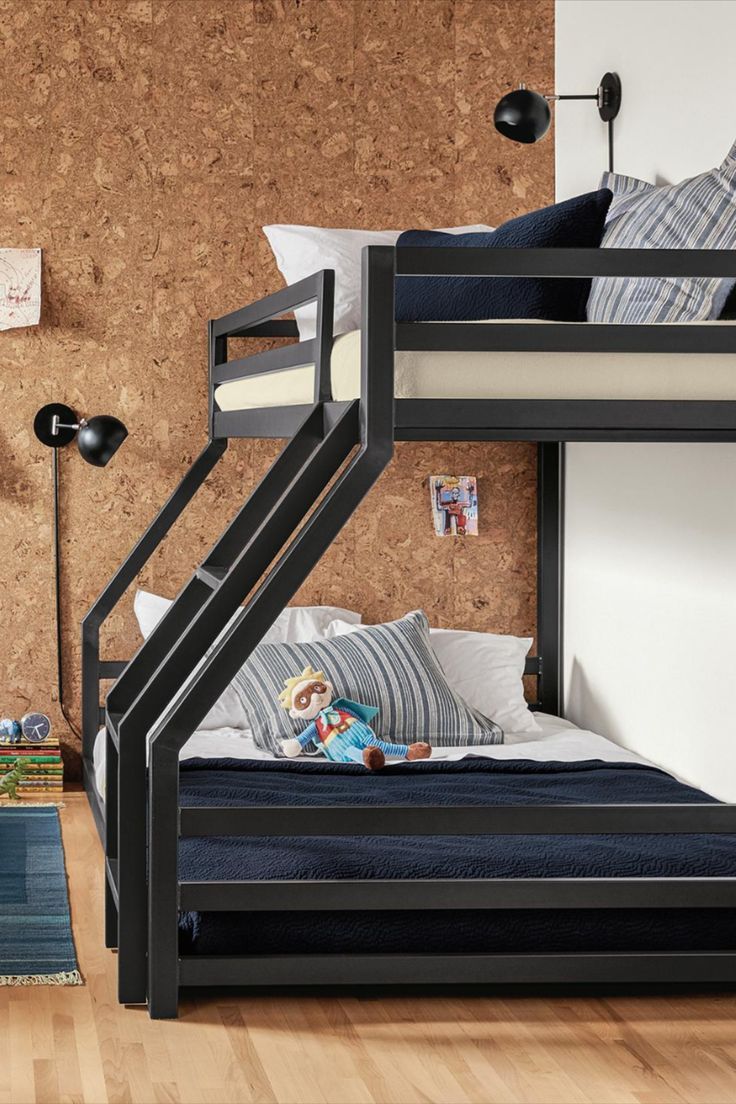 a bunk bed sitting next to a wall with pictures on it and a rug in front of it