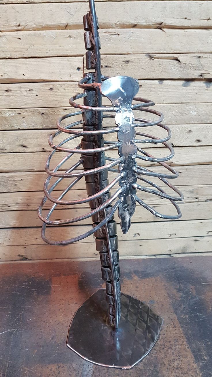 a metal sculpture with a skeleton on it's back