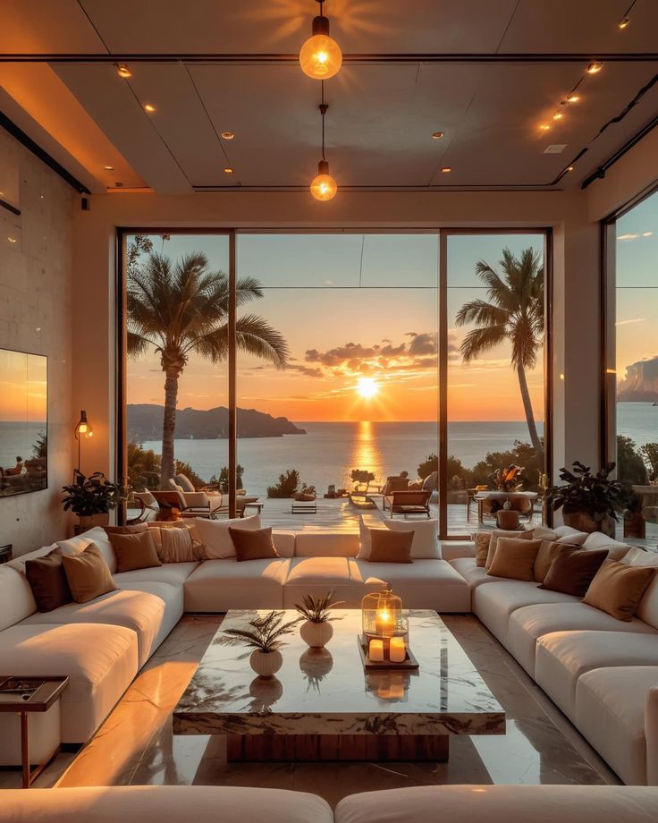 a living room filled with lots of furniture next to a window covered in palm trees