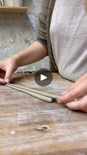 a woman is making chopsticks on a wooden table