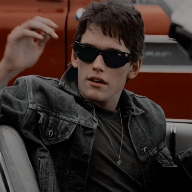 a young man wearing sunglasses sitting in a car