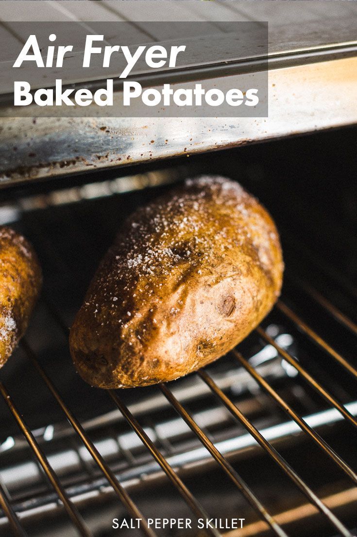 two baked potatoes sitting in an oven with the words air fryer baked potatoes above them