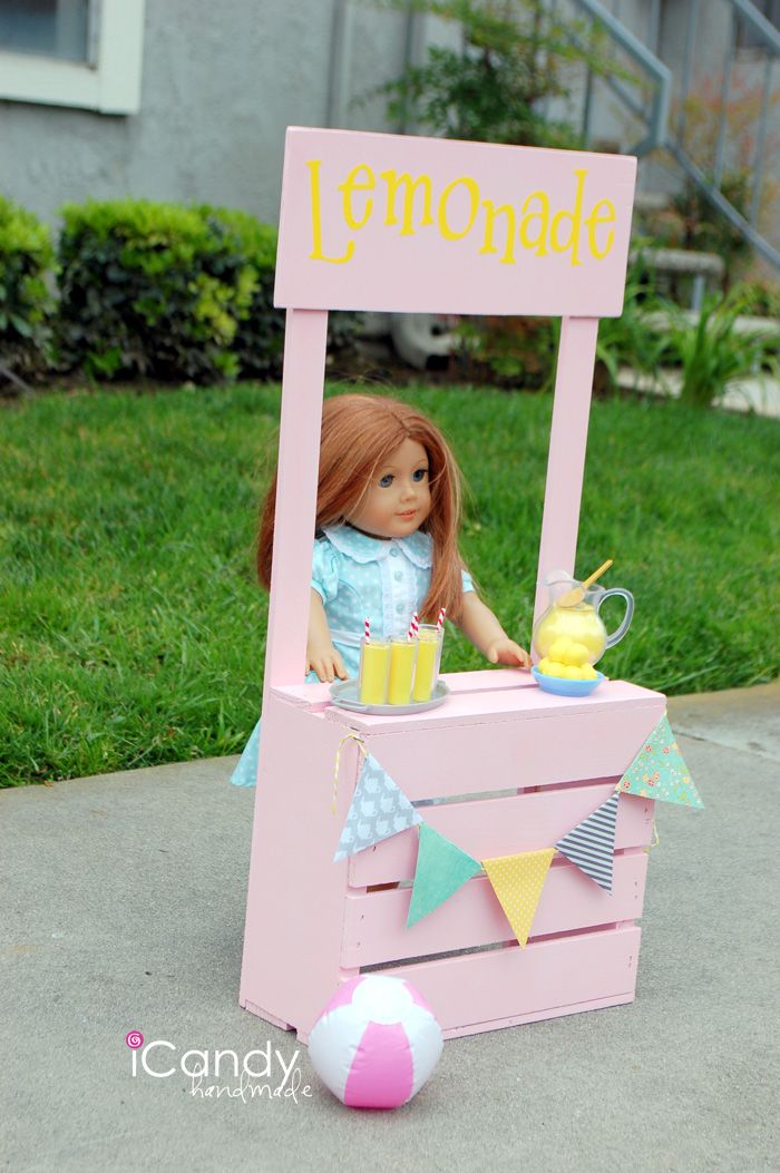 a doll is sitting in a lemonade stand