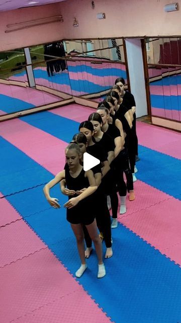 a group of young women standing on top of a blue and pink floor next to each other