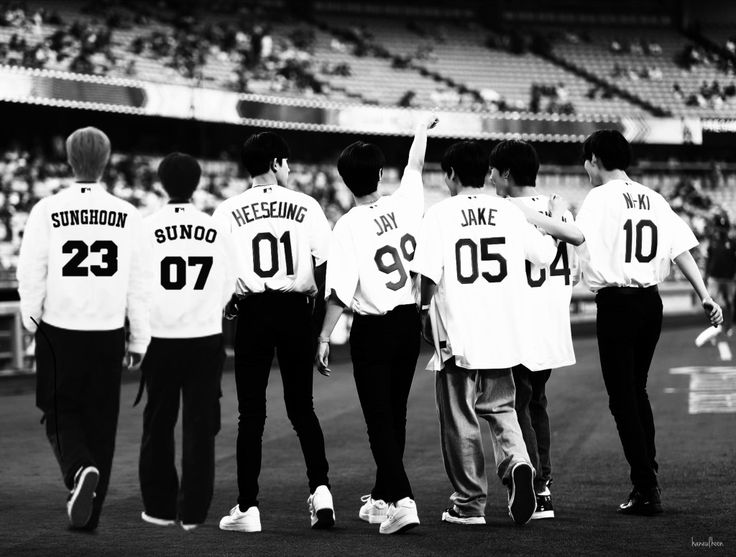 some baseball players are standing on the field and one has his hand up in the air