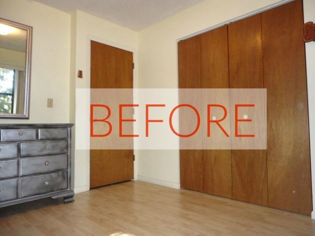 an empty room with wooden doors and a dresser