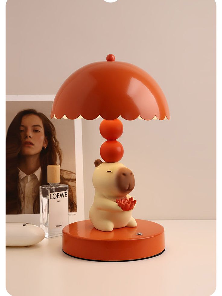 a lamp that is sitting on top of a table next to a photo and a bottle