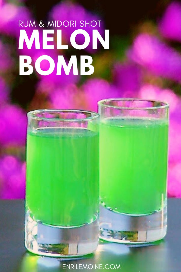 two glasses filled with green liquid sitting on top of a table